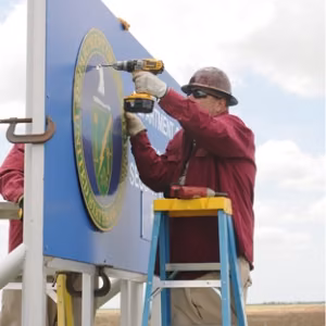 Workers put up a new entry sign at the Pantex